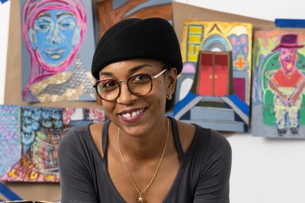 Tiffany Lawson smiles in front of her colorful art