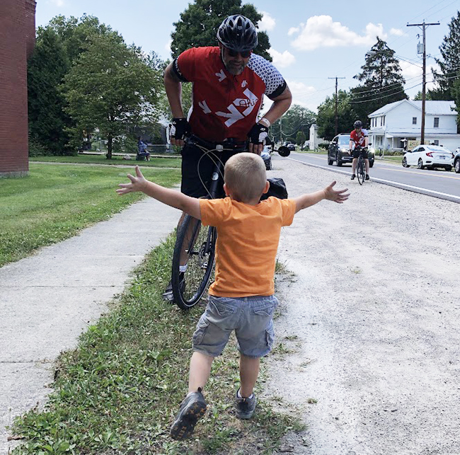 Jeremie Smith being joyfully greeted by his son, Isaac, during Pelotonia 2019.