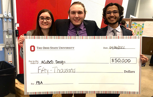 A Cubed Design team with a giant check
