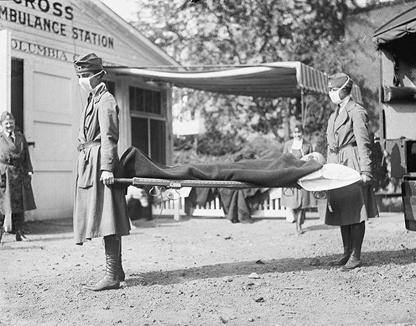 Two Red Cross carriers hold a patient with Spanish Flu