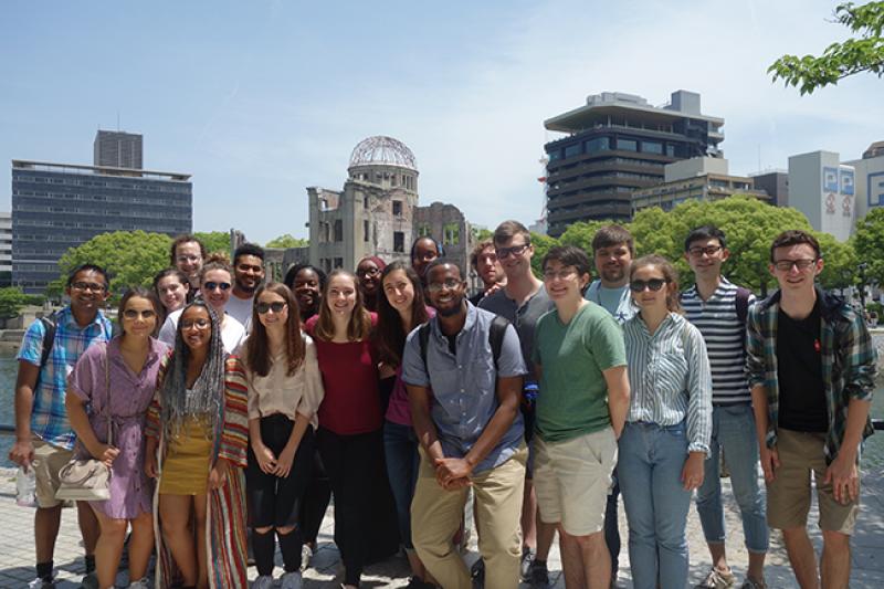 A group of students stand before the Hiroshima Peace Memorial, a building that withstood the atomic bombing of Hiroshima and is now preserved as a memorial the tens of thousands who lost their lives in the attack.