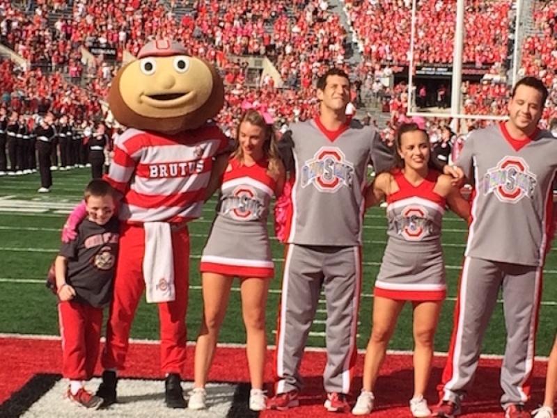 Evan stands with Brutus and the cheer team during Carmen Ohio