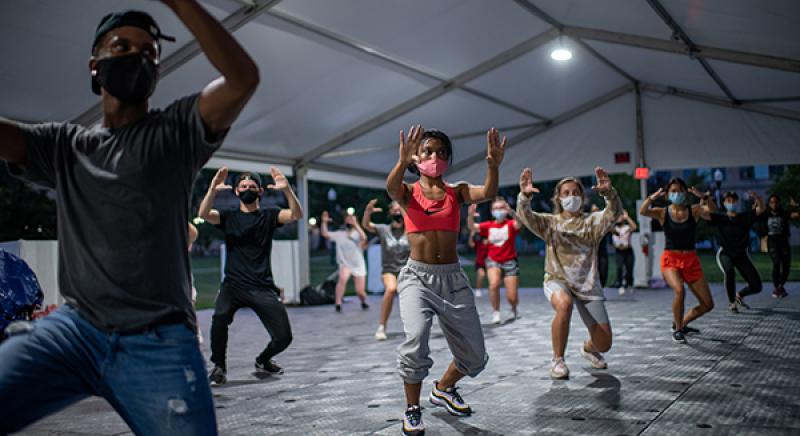 Students dance during a hip hop dance class in a specialized outdoor tent on the South Oval. Photo credit Jo McCulty.