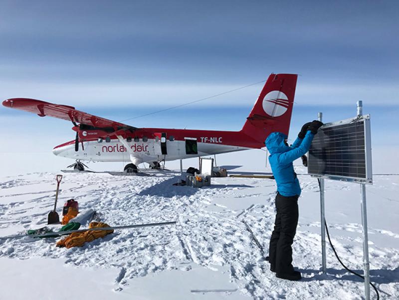 King checks on an instrument she and her team installed on the Greenland Ice Sheet in April 2018 to measure changes in surface accumulation and snow/ice compaction. 