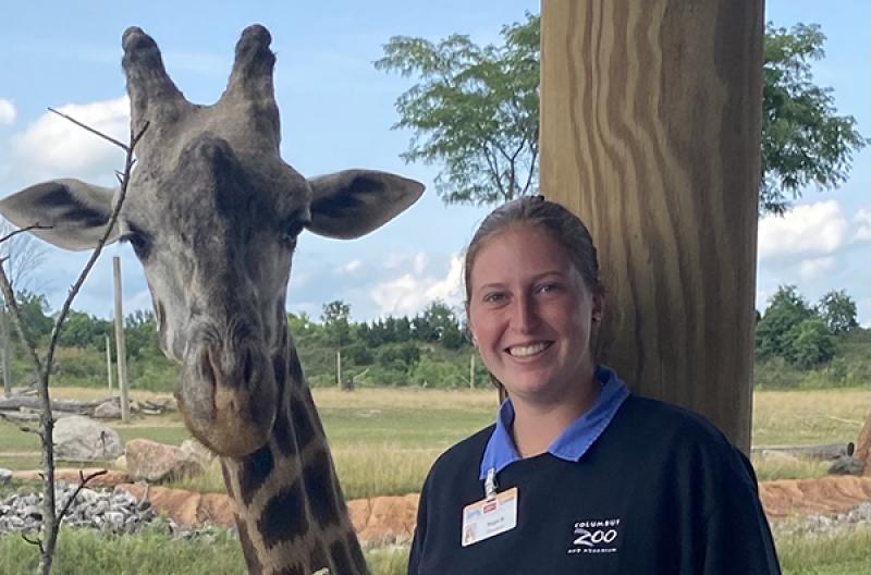 Maggie McCarter poses with a giraffe at the Columbus Zoo