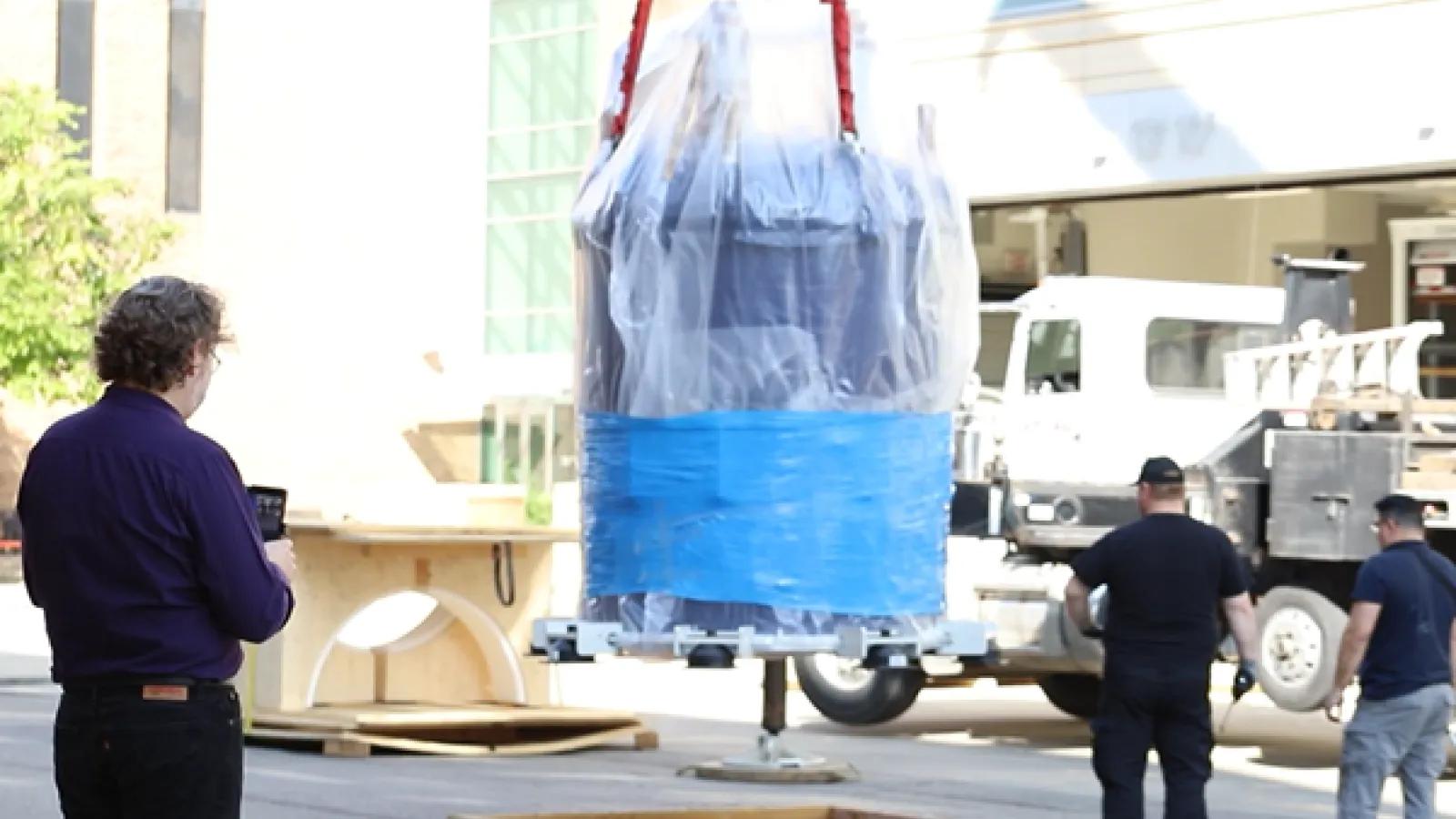 Lead Research Scientist Alexandar Hansen looks on as the massive NMR spectrometer is lowered in the CCIC.