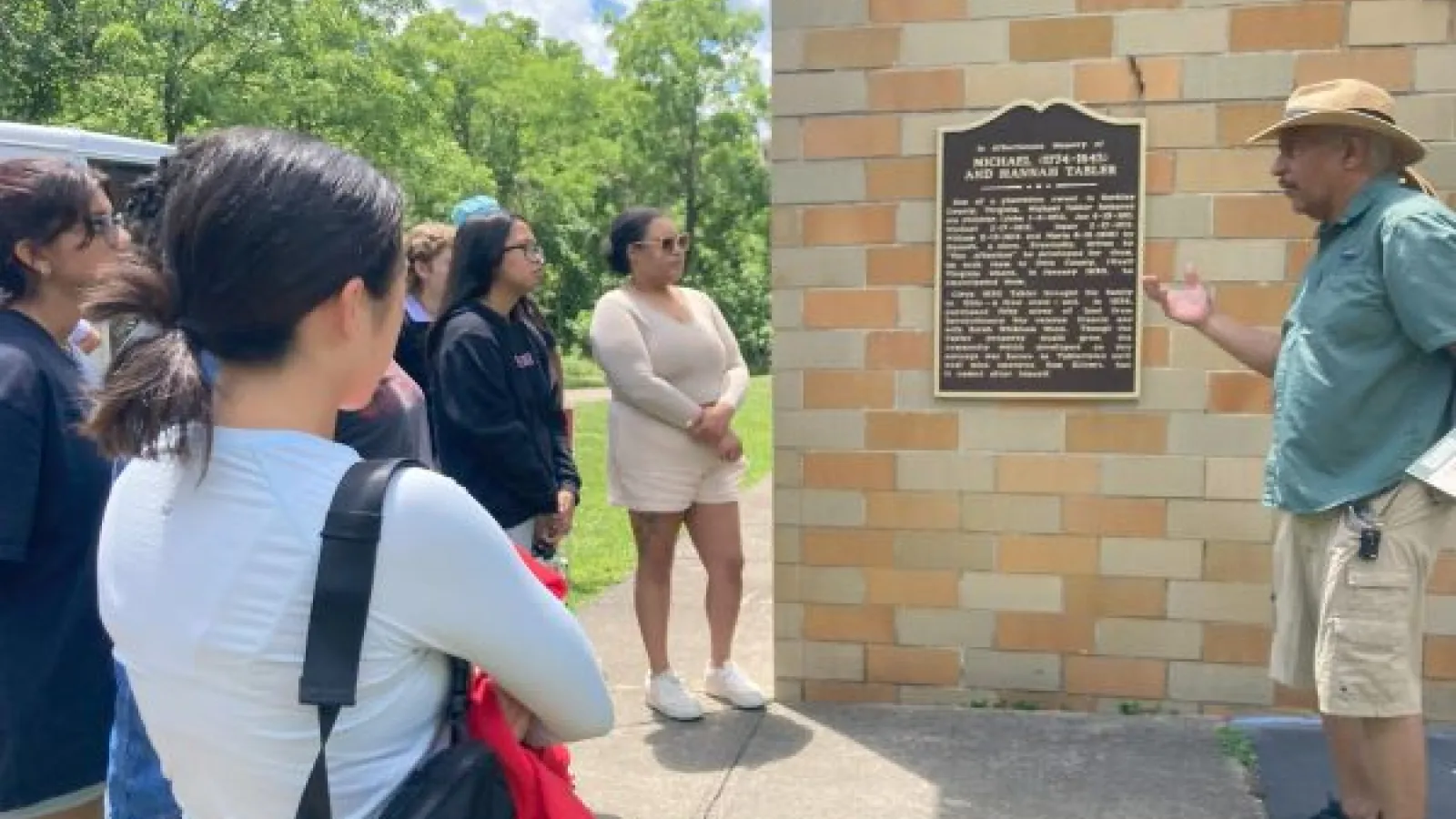 students look at a historical plaque