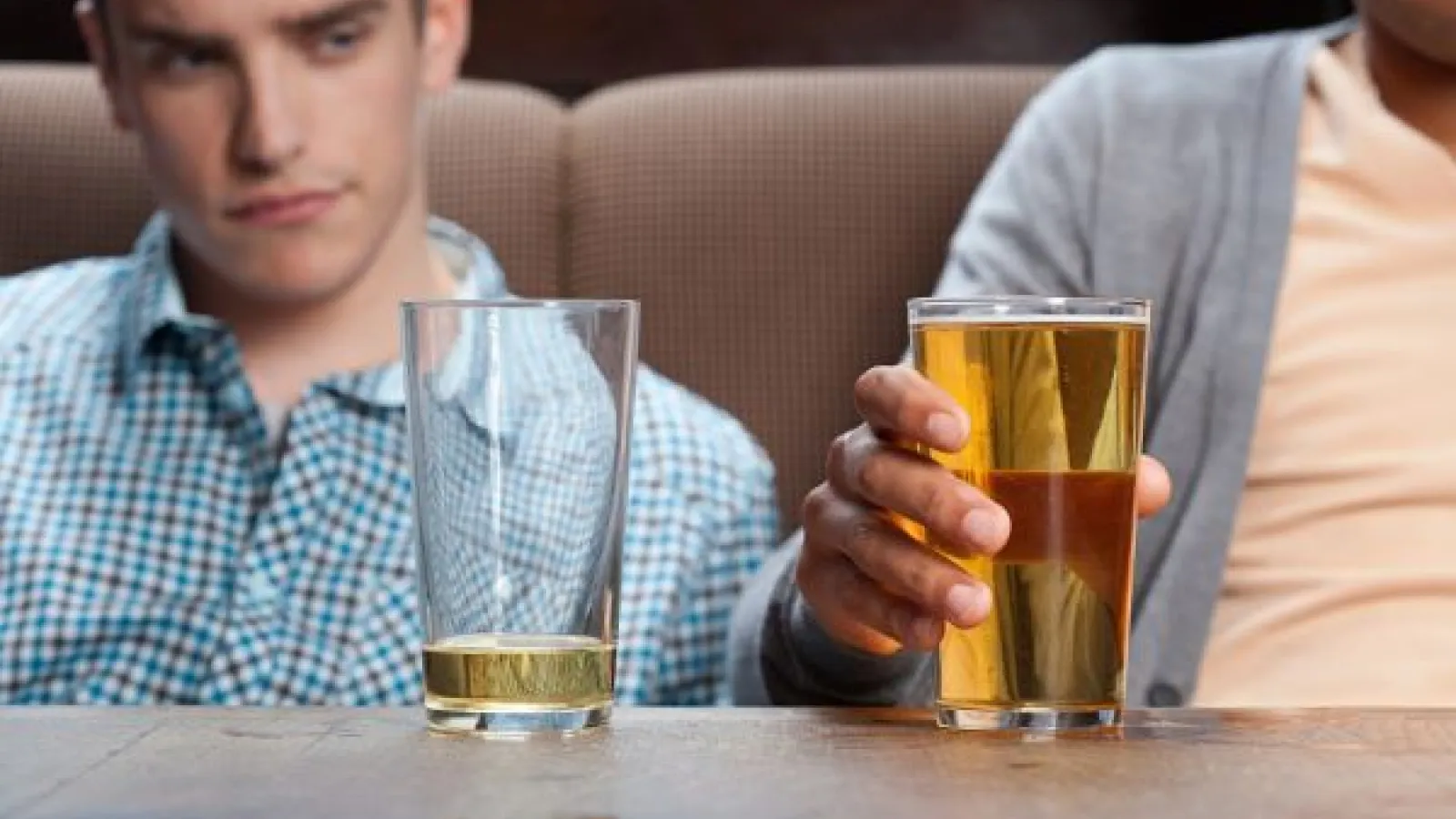 a man looks at his mostly empty beer glass