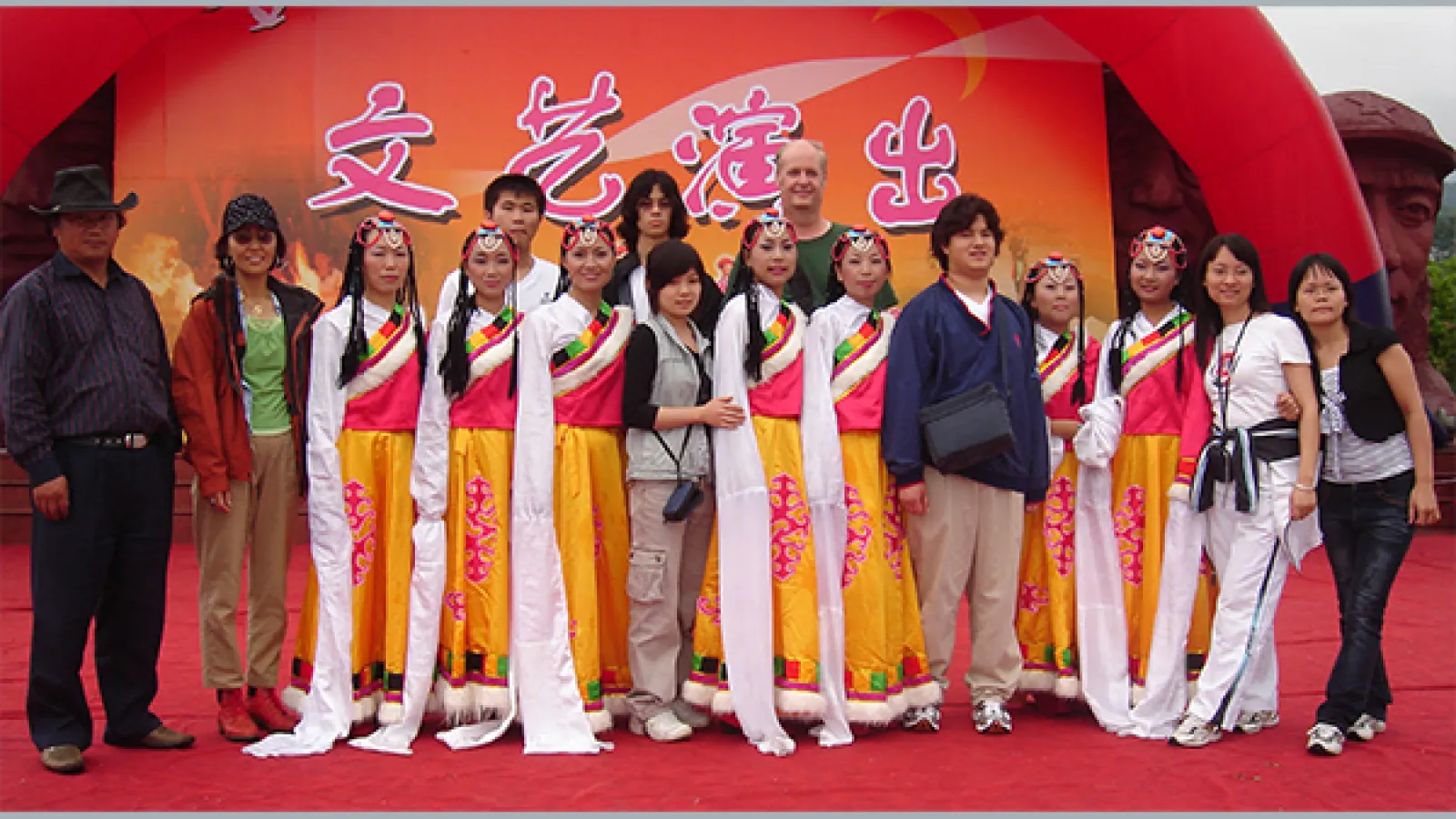 Professor Mark Bender and a group of students pose with a Tibetan dance troupe