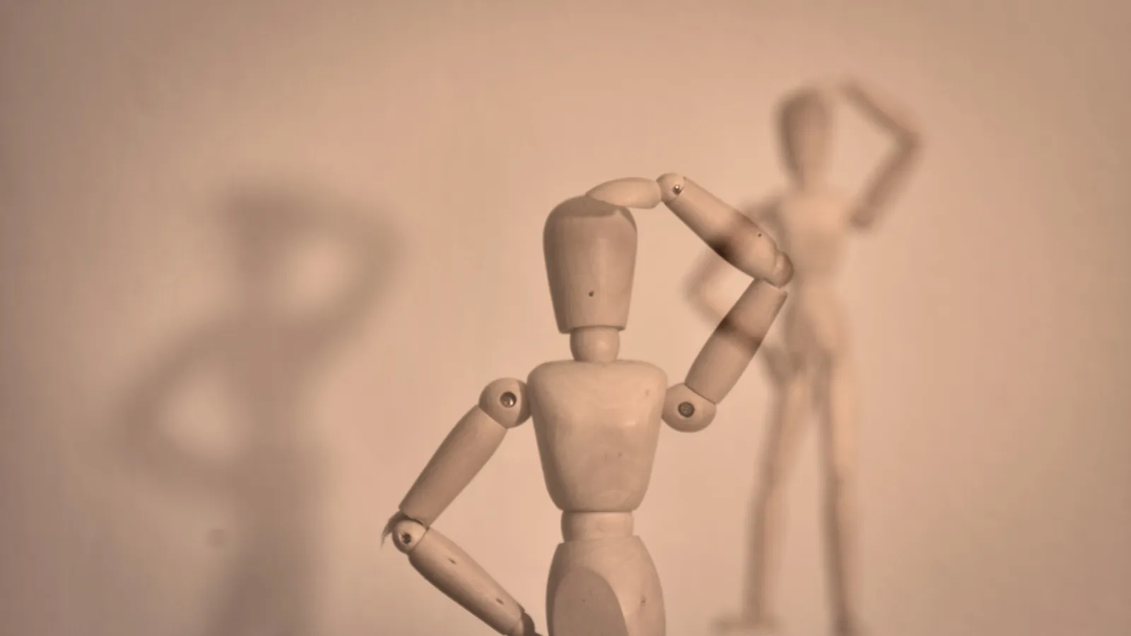 a wooden doll scratching its head pensively