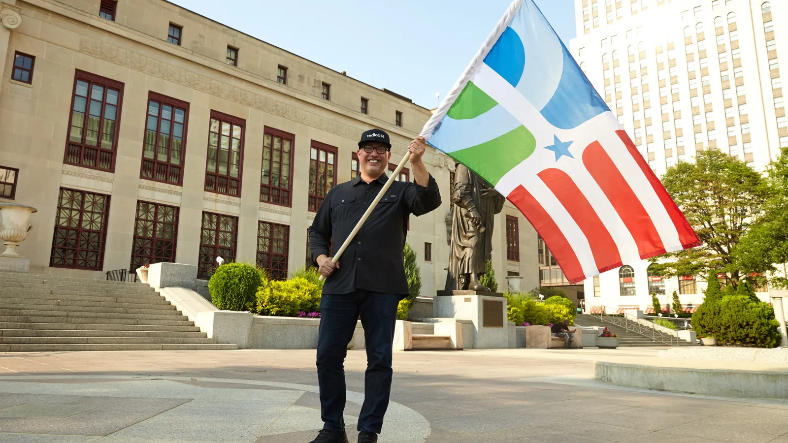 Professor of design Paul Nini waves The People's Flag of Columbus in front of Columbus City Hall. Photo courtesy of Brian Kaiser.
