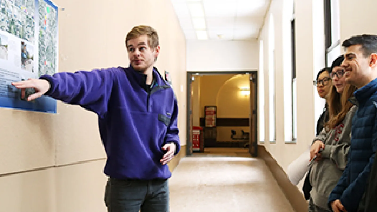Spencer Gilmore, a fourth-year economics student in Rick Livingston's American Food Cultures class, presents a poster of his to Peter Chan's Visual Design Communications class.