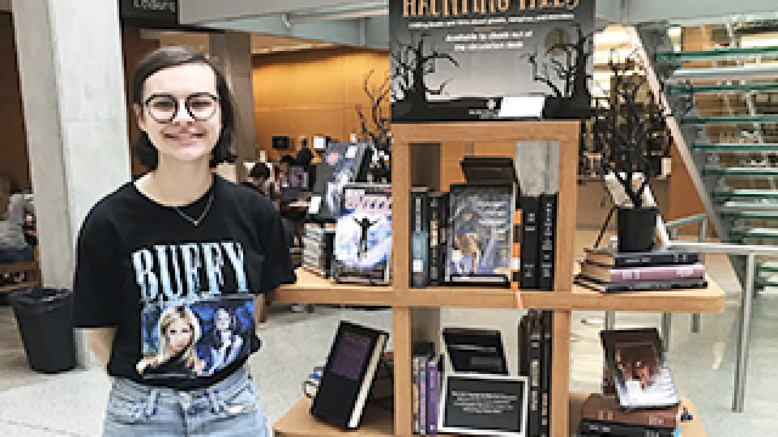 English major Rachel Stewart stands next to the display of horror literature in Thompson Library.