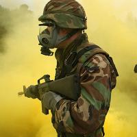 Soldier wearing a gas mask in yellow smoke