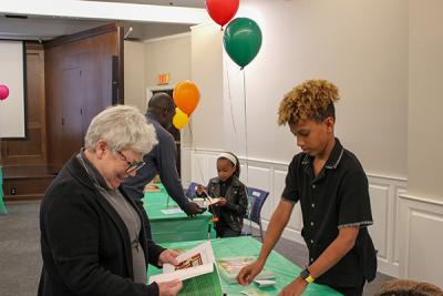 A child discusses his book with a showcase attendee