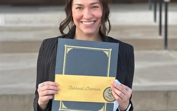 Ashland Damron holding an award