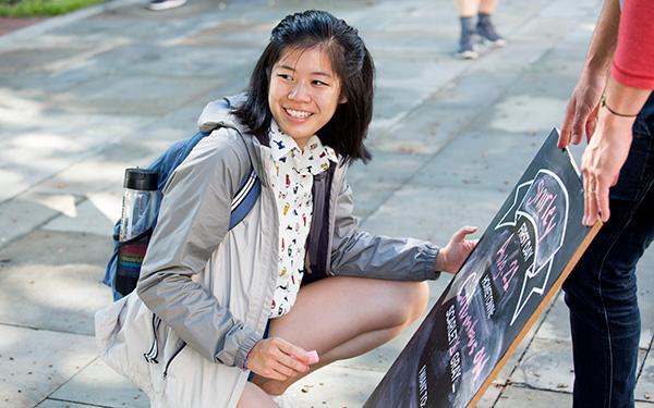 An Asian student writing on a chalkboard