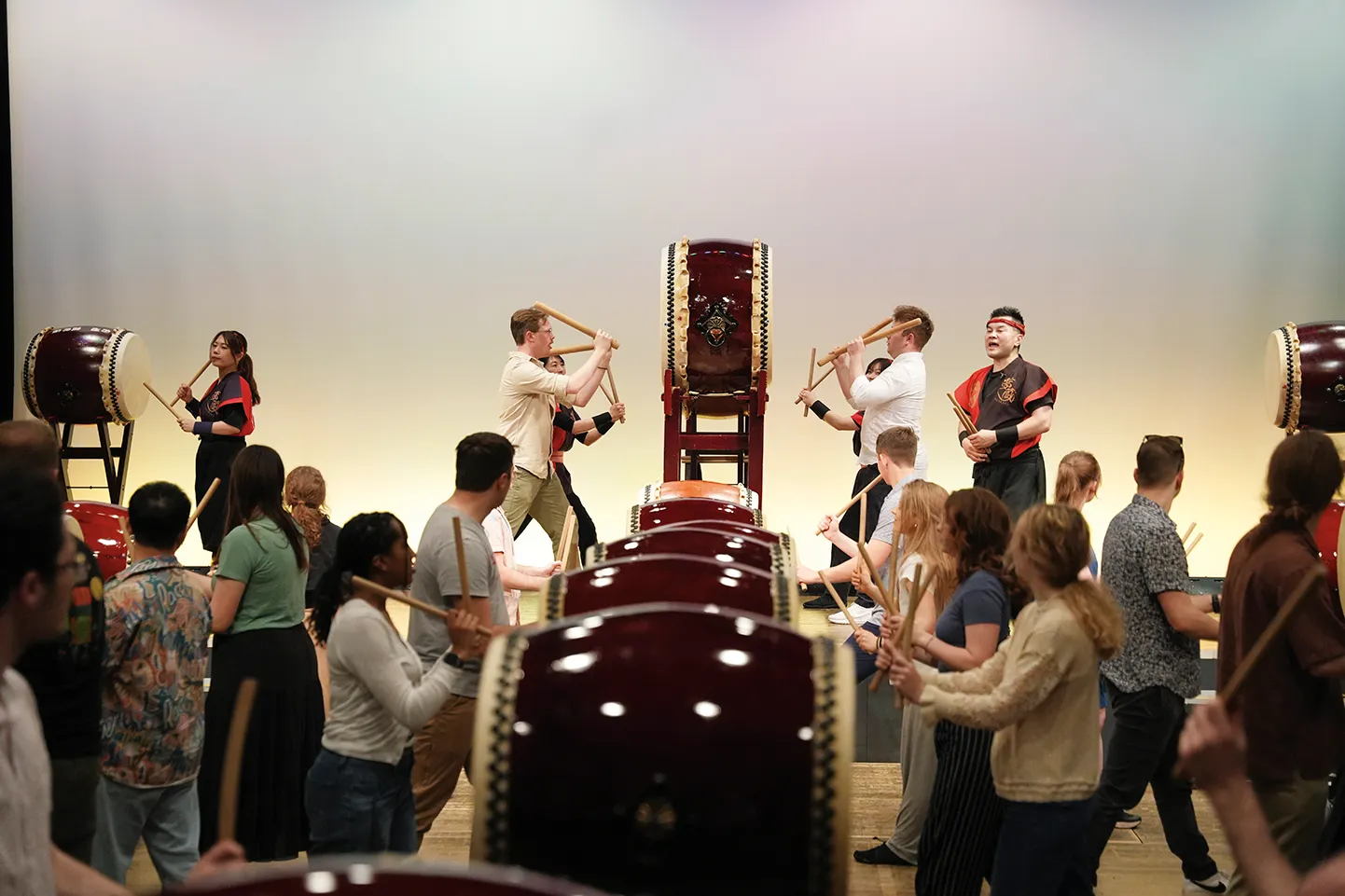 5Two Wind Symphony members join taiko drum masters on stage for a demonstration in front of the group