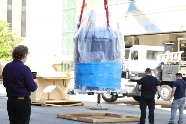 Lead Research Scientist Alexandar Hansen looks on as the massive NMR spectrometer is lowered in the CCIC.