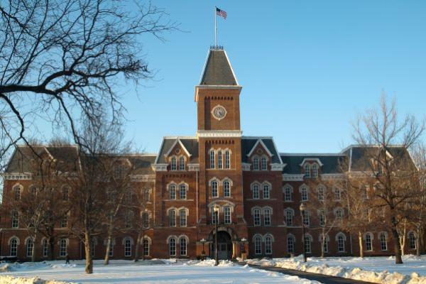 University Hall, a brick building with a tall clocktower, on a clear winter day