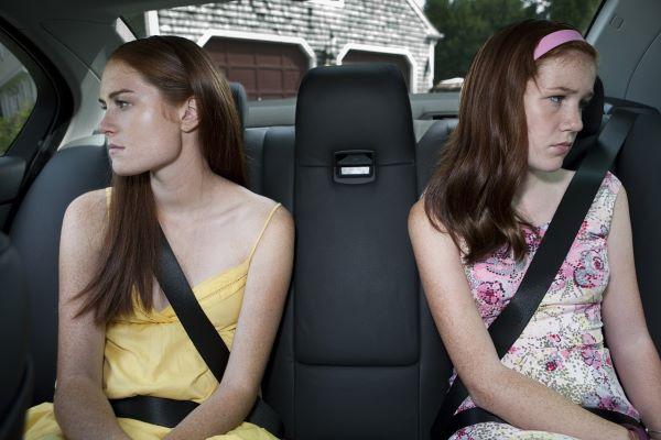 Sullen sisters in the back seat of a car