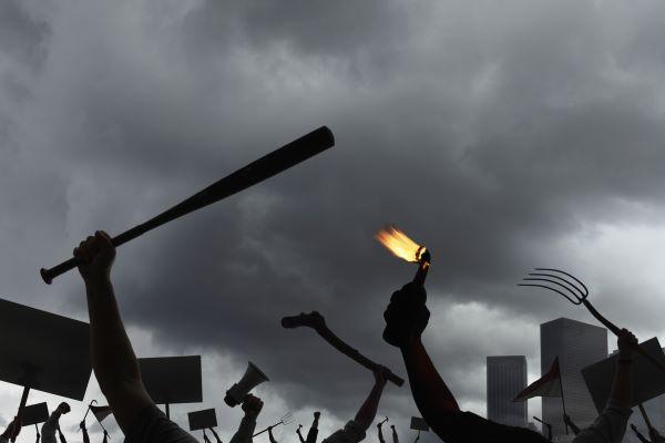 raised hands holding a baseball bat and a molotov cocktail