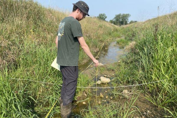 Joe Gentine, a former graduate student at Ohio State’s Aquatic Ecology Laboratory, samples Shallow Run upstream of a U.S. Geological Survey gaging station.