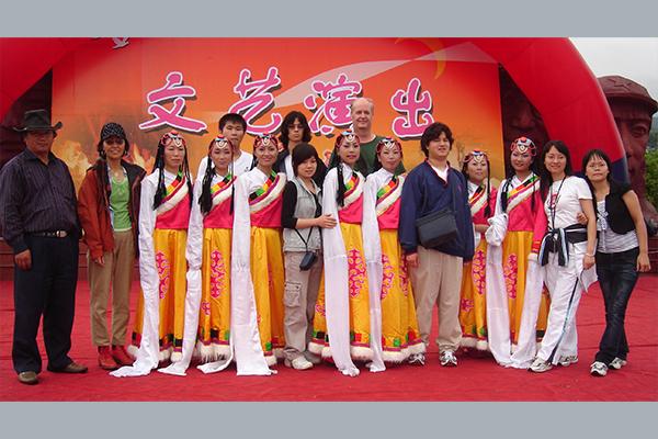 Professor Mark Bender and a group of students pose with a Tibetan dance troupe