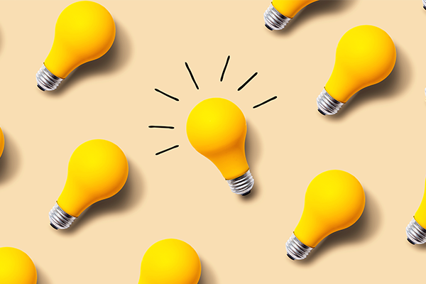 Yellow lightbulbs scattered on a light yellow background. 