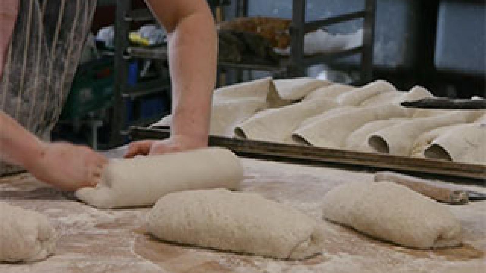A bread maker neading dough