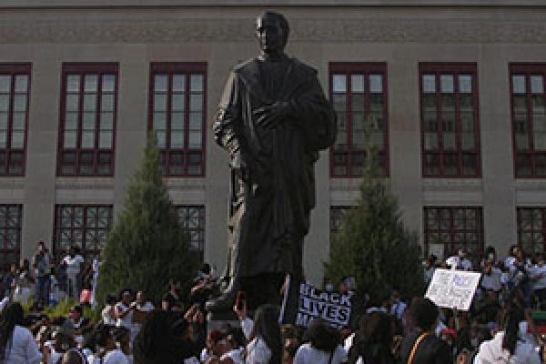 A protest in front of a historical statue
