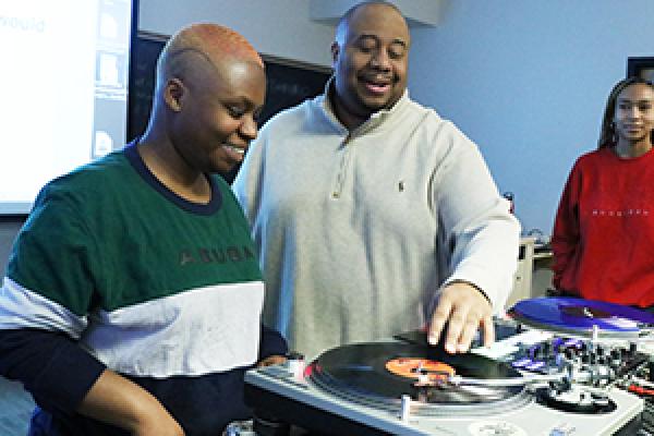 Jason Rawls demonstrates how to scratch on a record for a student