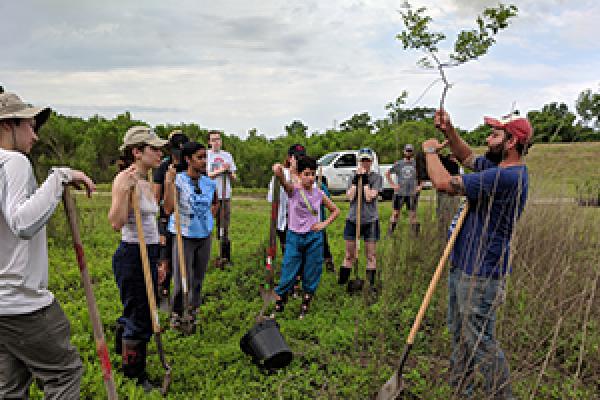Ohio State students learn about saplings they are about to plant during a field school in southern Louisiana. Photo credit: Mary Thomas