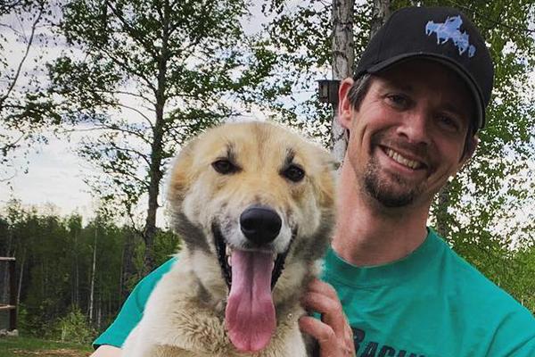 Matthew Failor poses with one of his sled dogs
