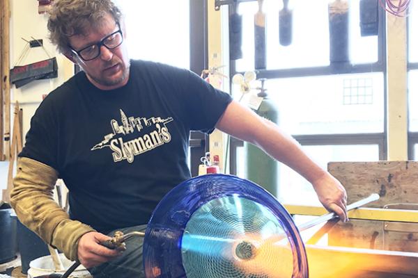 Jonathan Capps, a glassmaker in the Department of Art, uses a blowtorch on a piece of glass art he's making. Capps will spend nine months in Finland for a Fulbright-funded research project.