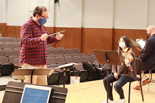 Jae Park conducts during rehearsal.